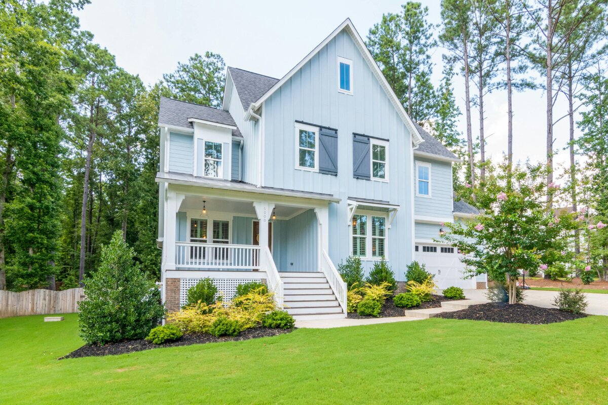 Blue board-and-batten farmhouse with seamless gutters